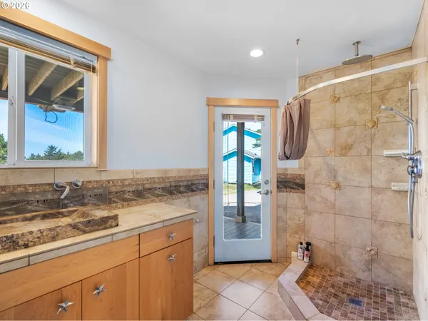 a bathroom with a granite countertop sink a mirror and a shower