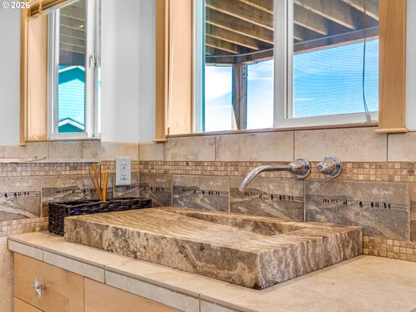 a bathroom with a granite countertop sink and a window