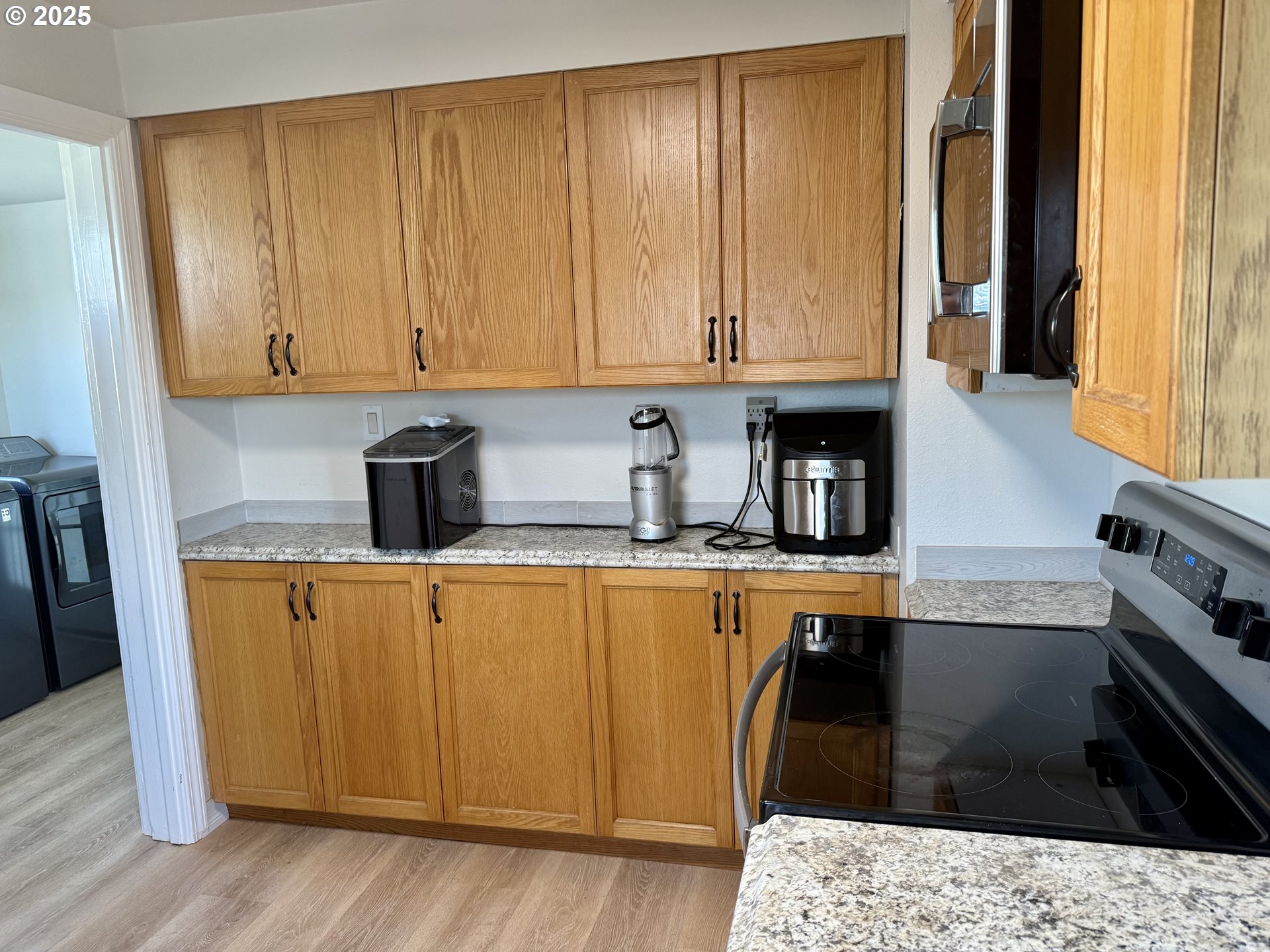 345 38th Street Springfield, OR 97478 - Photo 8 of 29 a kitchen with stainless steel appliances kitchen island wooden cabinets a sink and a window