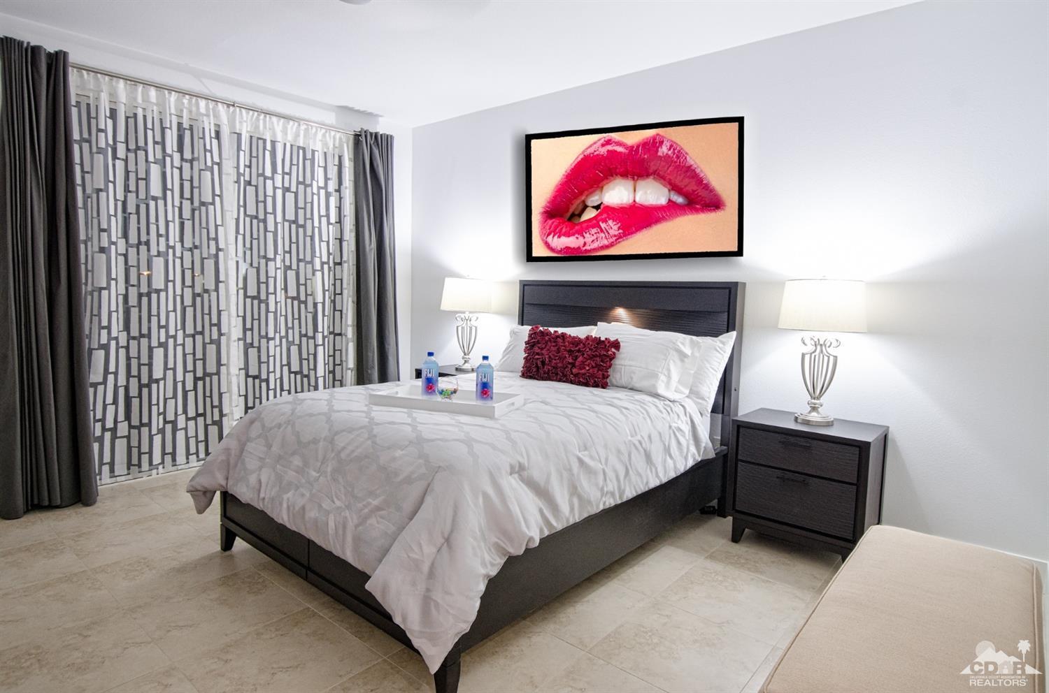 125 Lakeshore Drive Rancho Mirage, CA 92270 - Photo 20 of 79 a bedroom with a bed and a painting on the wall