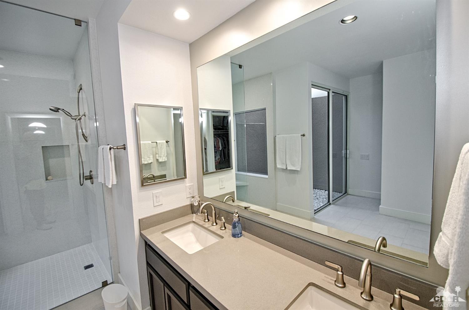 125 Lakeshore Drive Rancho Mirage, CA 92270 - Photo 26 of 79 a bathroom with a sink vanity granite shower and a mirror