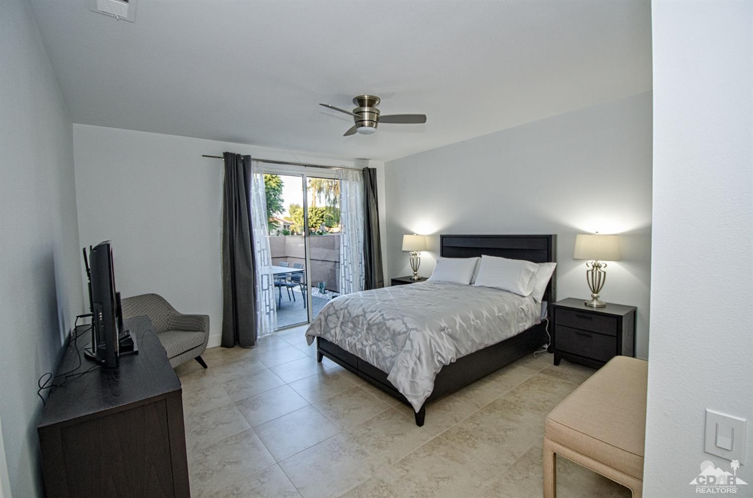 125 Lakeshore Drive Rancho Mirage, CA 92270 - Photo 28 of 79 a bedroom with a bed and a chair