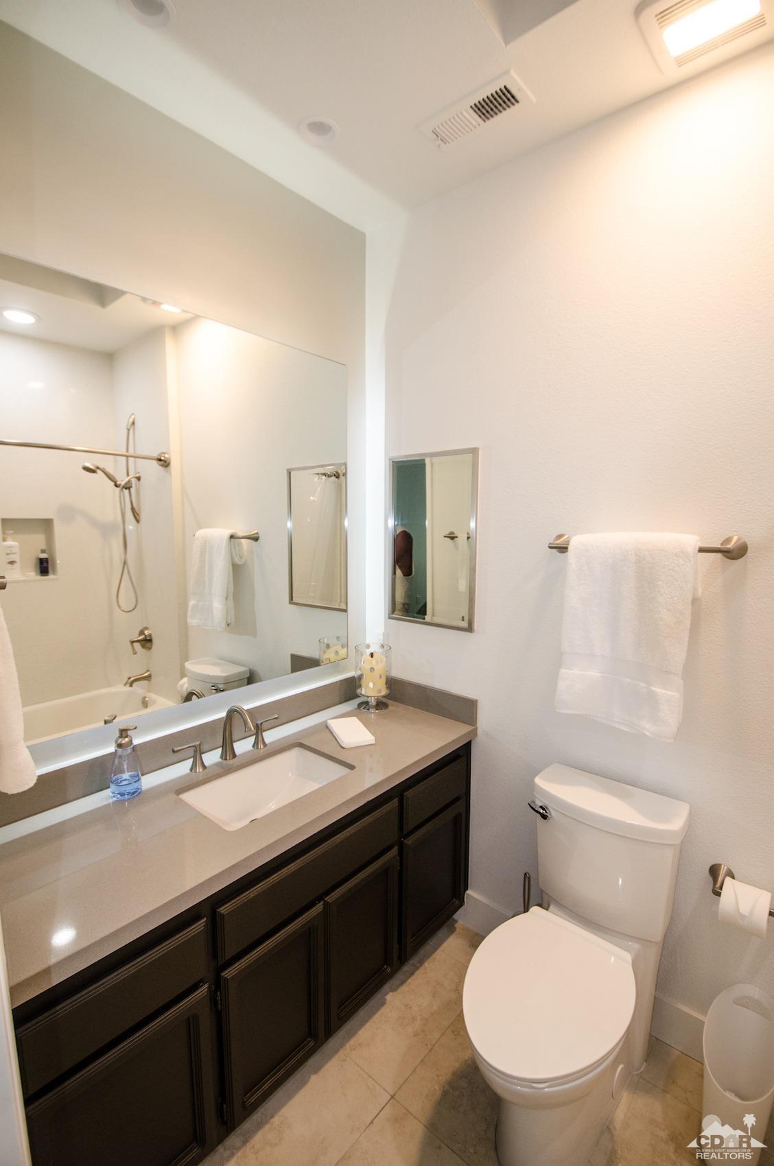 125 Lakeshore Drive Rancho Mirage, CA 92270 - Photo 35 of 79 a bathroom with a granite countertop toilet sink and mirror