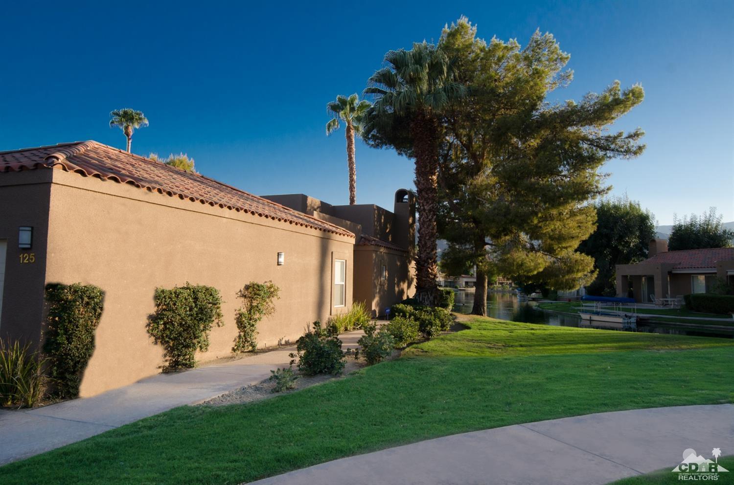 125 Lakeshore Drive Rancho Mirage, CA 92270 - Photo 49 of 79 a view of a white house with a big yard and potted plants