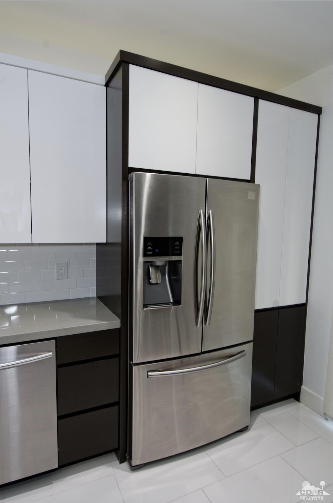 125 Lakeshore Drive Rancho Mirage, CA 92270 - Photo 51 of 79 a metallic refrigerator freezer sitting in a kitchen