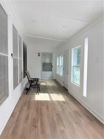 a view of an empty room with glass door and windows