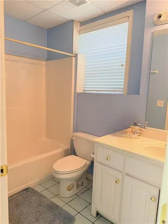 a bathroom with a granite countertop sink toilet a mirror and shower