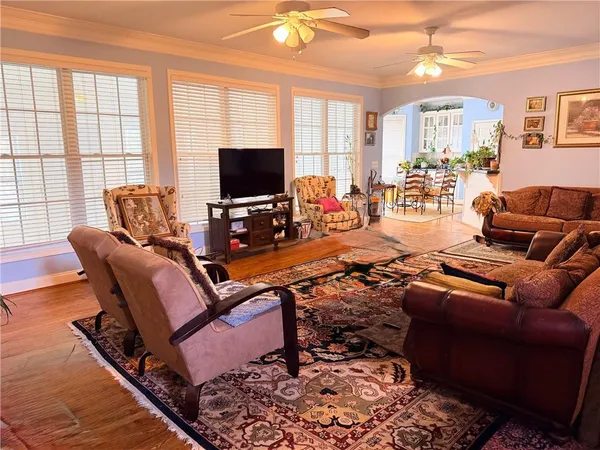 a living room with furniture a flat screen tv and a large window