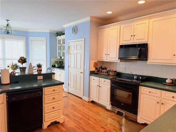 a kitchen with granite countertop a sink stove and refrigerator