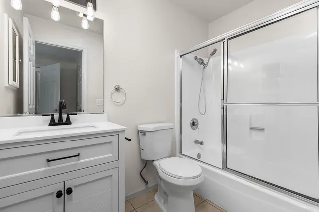a bathroom with a sink a mirror a toilet and shower