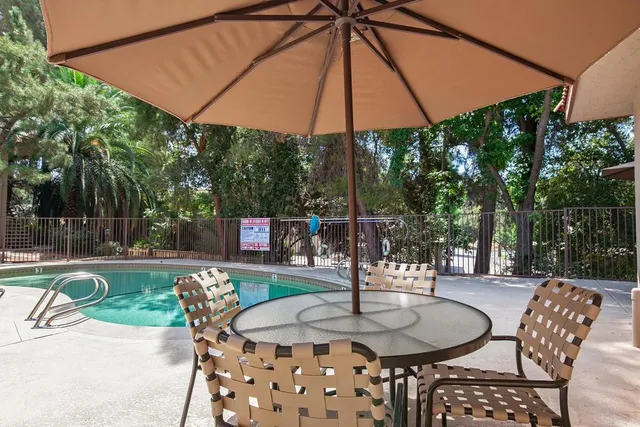 a patio with a table and chairs under an umbrella