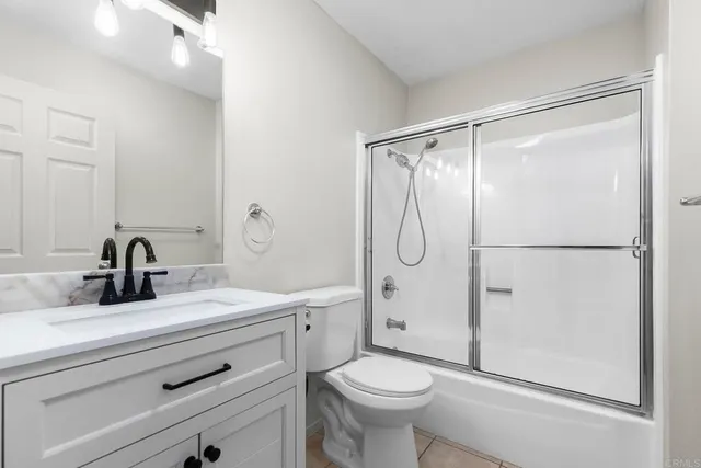 a bathroom with a shower sink vanity and toilet