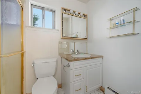 a bathroom with a granite countertop toilet sink and mirror