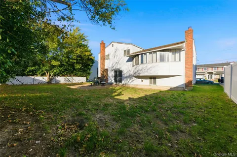 a view of a house with a big yard and sitting area