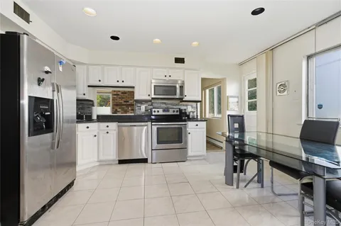 a kitchen with stainless steel appliances granite countertop a refrigerator and a stove top oven