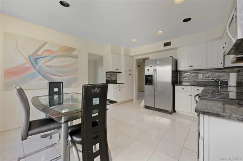 a kitchen with stainless steel appliances granite countertop a refrigerator and a stove top oven