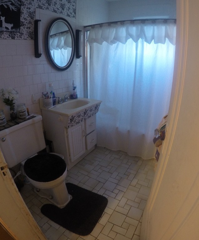 215 Beverly Road Worcester, MA 01605 - Photo 8 of 8 a bathroom with a granite countertop sink a mirror and a toilet
