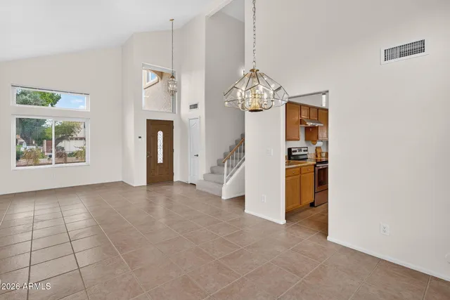 a living room with furniture kitchen view and a large window