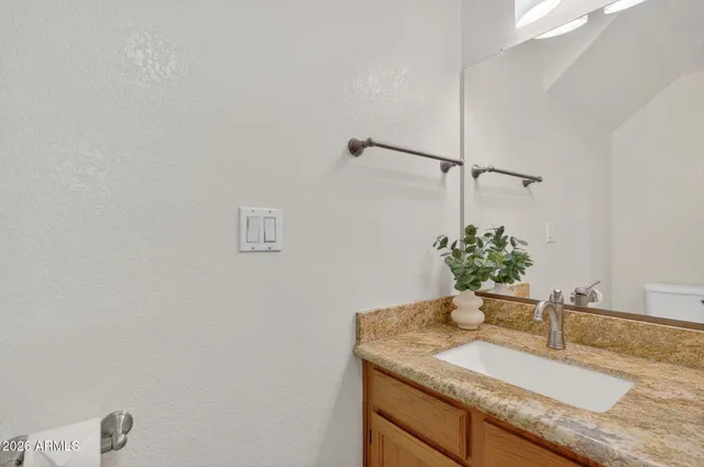 a bathroom with a granite countertop sink a mirror and a shower