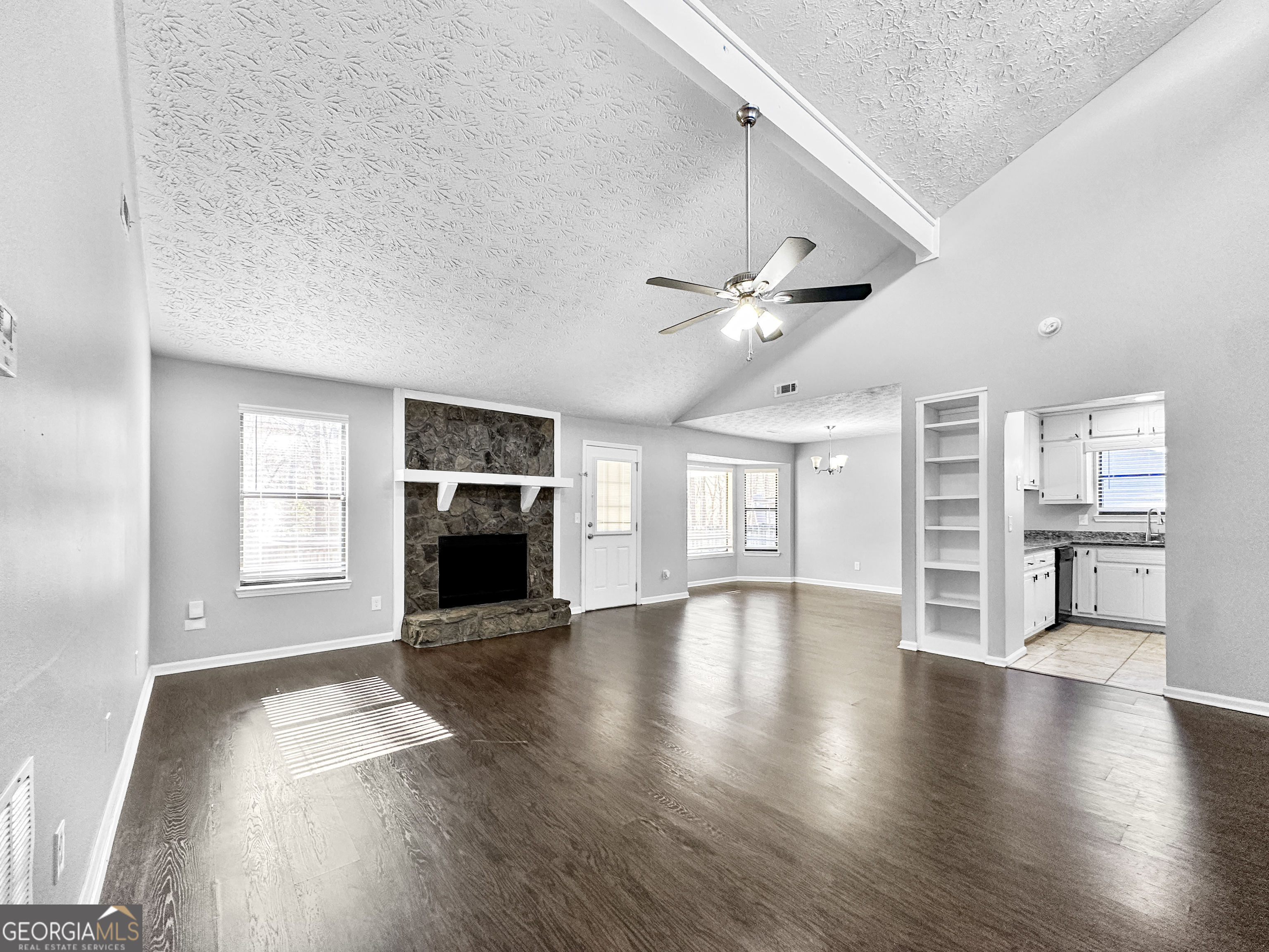 1299 Bugle Court Hampton, GA 30228 - Photo 4 of 18 an empty room with wooden floor fireplace and windows