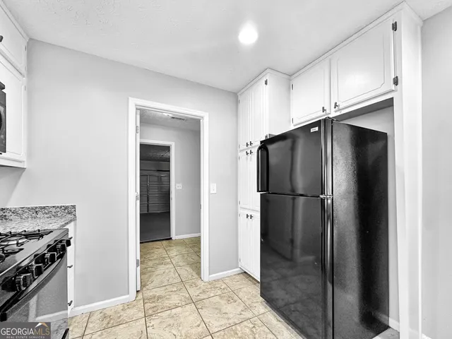 a kitchen with stainless steel appliances granite countertop a refrigerator and a stove top oven