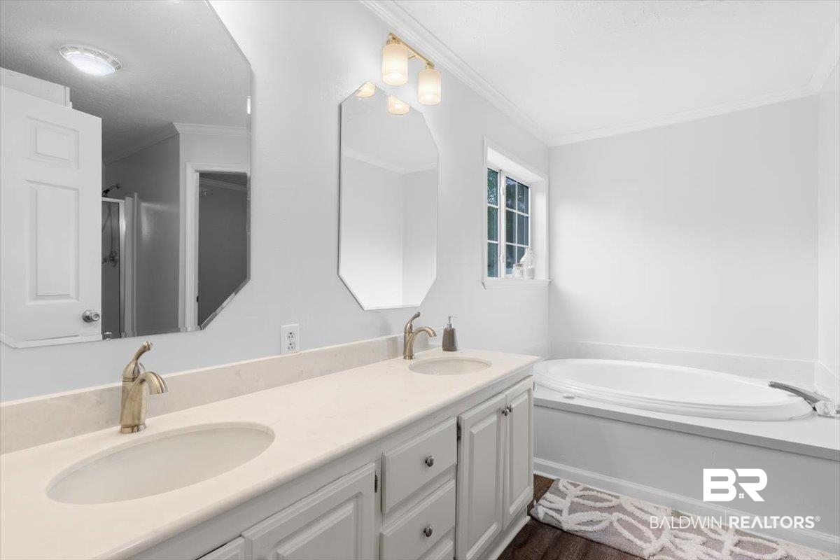 6971 March Road Theodore, AL 36582 - Photo 14 of 26 Bathroom featuring double vanity, a sink, ornamental molding, and a bath