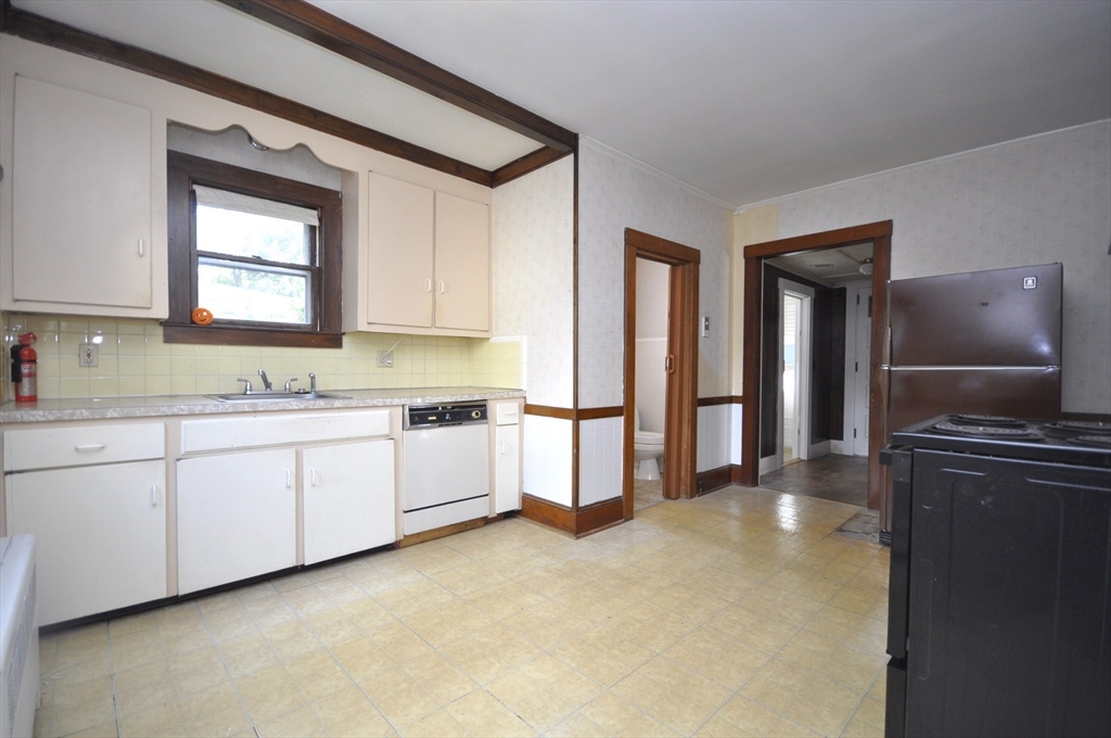 164 Warren Avenue Whitman, MA 02382 - Photo 17 of 34 a kitchen with granite countertop a refrigerator sink and cabinets