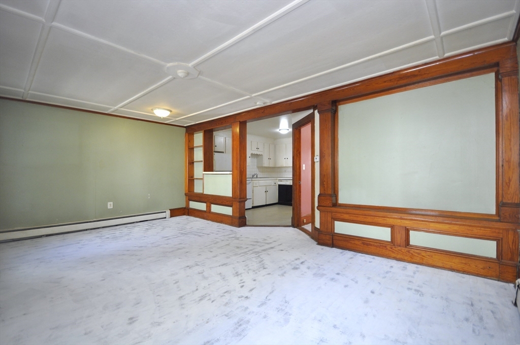 164 Warren Avenue Whitman, MA 02382 - Photo 21 of 34 an empty room with wooden floor and exposed radiator