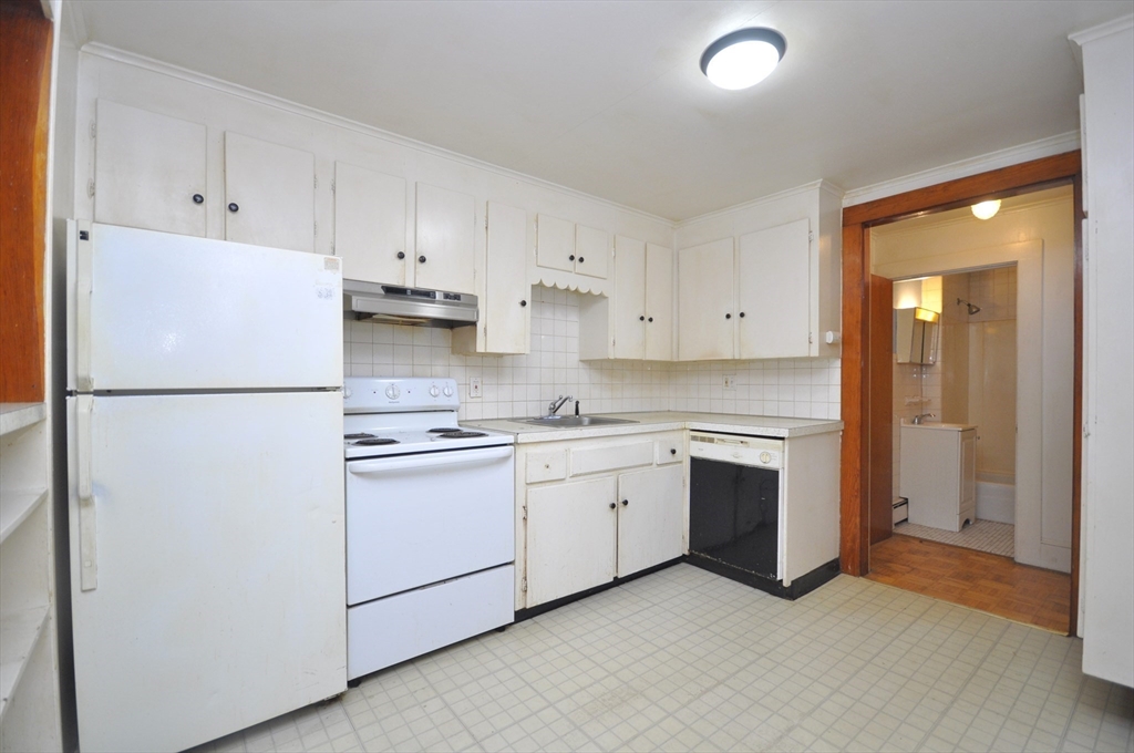 164 Warren Avenue Whitman, MA 02382 - Photo 22 of 34 a kitchen with stainless steel appliances granite countertop white refrigerator stove a sink and white cabinets