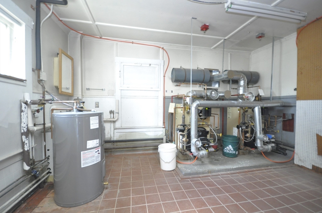 164 Warren Avenue Whitman, MA 02382 - Photo 26 of 34 a room with water heater and wooden cabinets