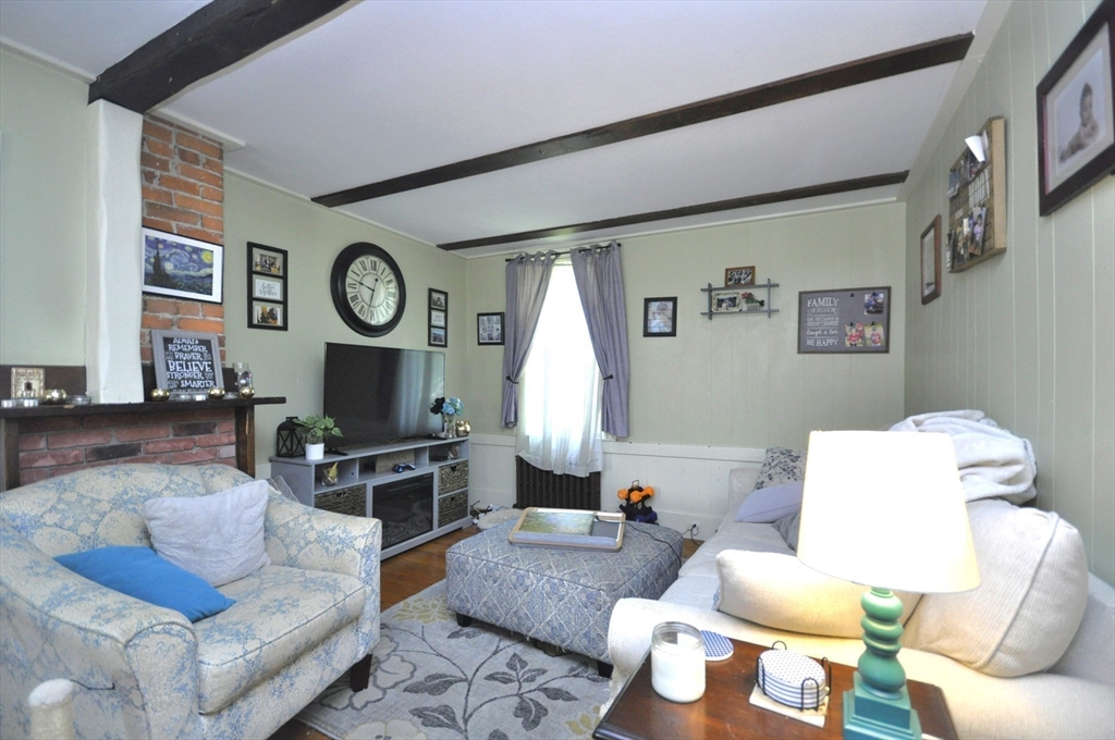 164 Warren Avenue Whitman, MA 02382 - Photo 7 of 34 a living room with furniture and a clock