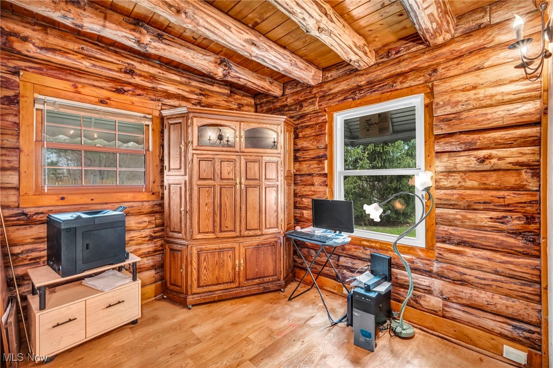 24455 Tryon Road Oakwood, OH 44146 - Photo 27 of 40 Home office with beamed ceiling, light wood-style flooring, log walls, and wooden ceiling