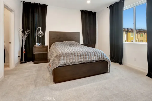 a bed sitting in a bedroom next to a window