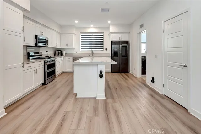 a large white kitchen with kitchen island sink stove and refrigerator