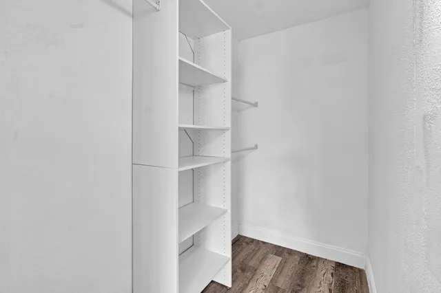 a view of walk in closet with empty racks