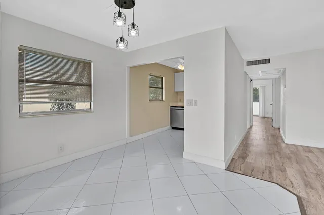 a view of a hallway with wooden floor and cabinet
