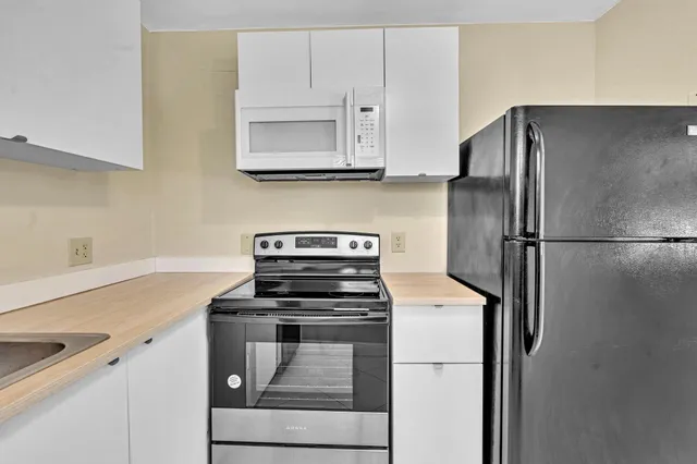 a kitchen with white cabinets and stainless steel appliances