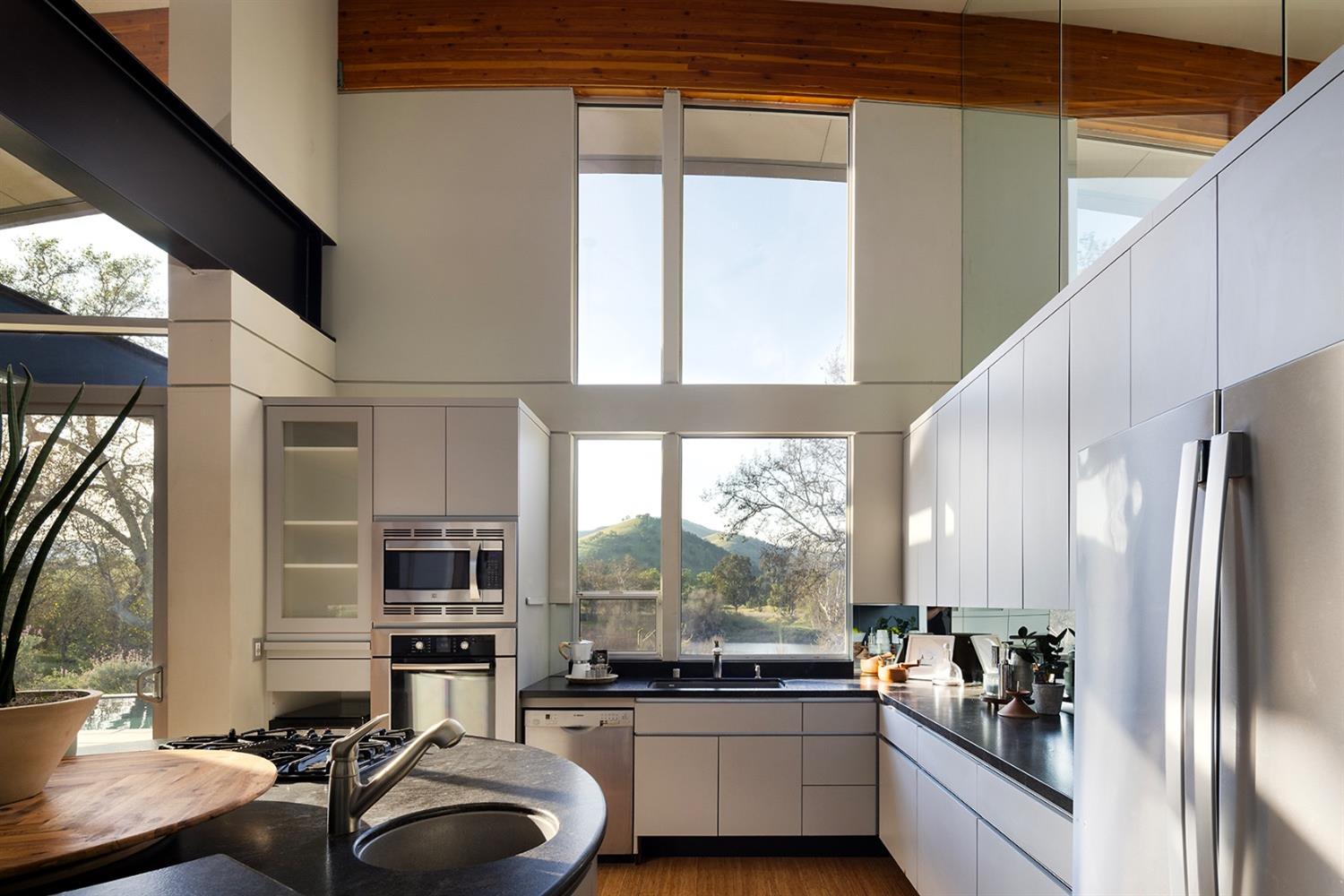26210 Elwood Road Sanger, CA 93657 - Photo 15 of 36 a kitchen with kitchen island granite countertop a sink appliances cabinets and a counter top space