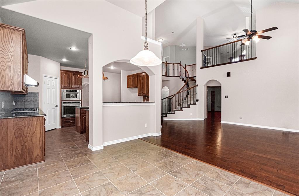 1325 Bateman Lane Celina, TX 75009 - Photo 5 of 39 a kitchen with stainless steel appliances kitchen island granite countertop a refrigerator a stove and a sink with wooden floor