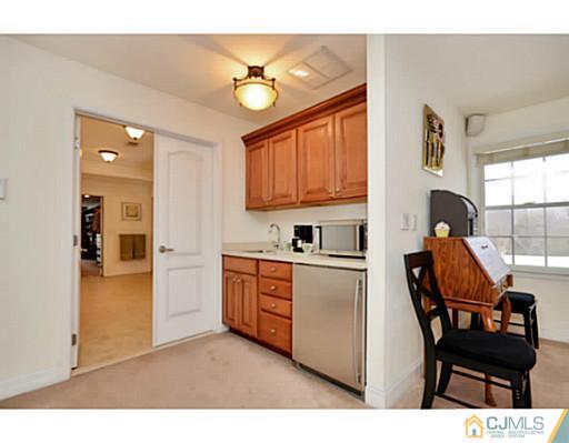 4 Rustic Court Monroe Township, NJ 08831 - Photo 16 of 25 a kitchen with stainless steel appliances kitchen island granite countertop a stove a sink and a refrigerator with wooden floor