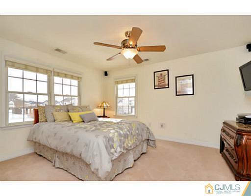 4 Rustic Court Monroe Township, NJ 08831 - Photo 20 of 25 a bedroom with a large bed and a chandelier