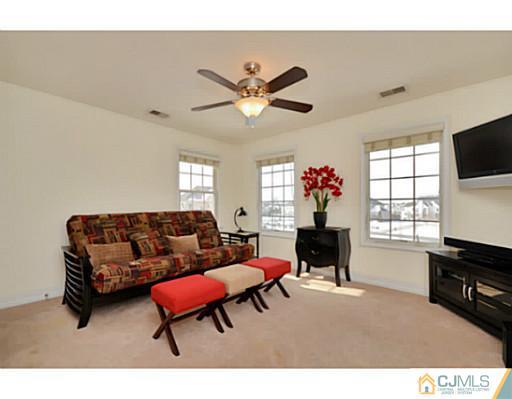 4 Rustic Court Monroe Township, NJ 08831 - Photo 21 of 25 a living room with furniture a fireplace and a flat screen tv