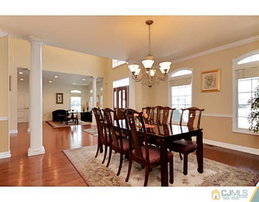 4 Rustic Court Monroe Township, NJ 08831 - Photo 4 of 25 a view of a dining room and livingroom with furniture wooden floor a rug a potted plant and a chandelier