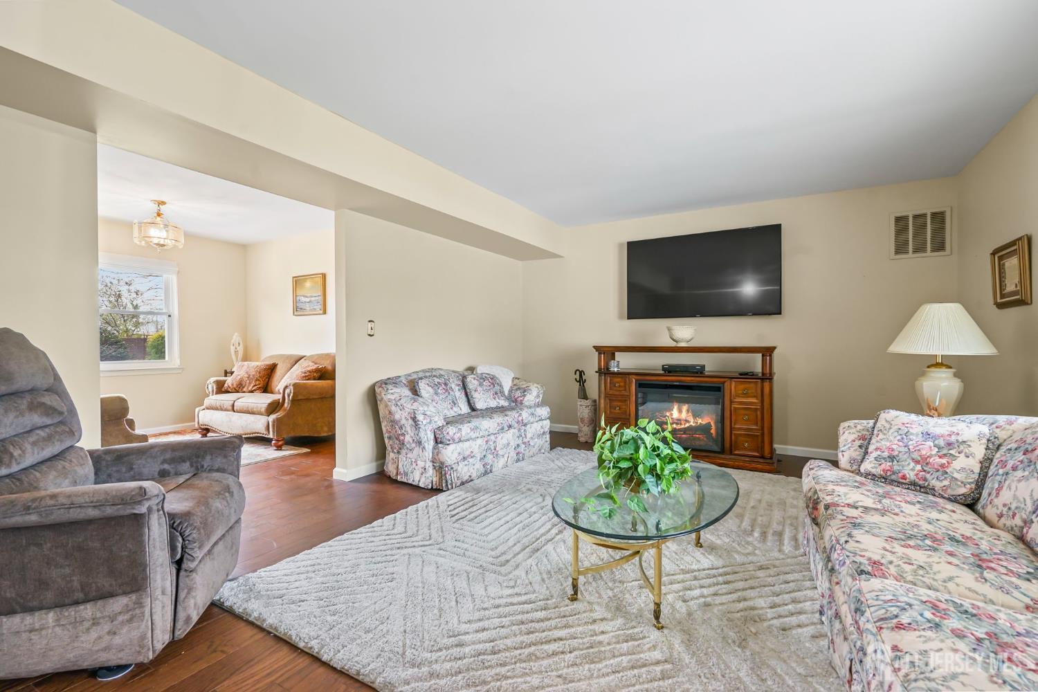 41 Rodak Circle Edison, NJ 08817 - Photo 7 of 28 a living room with furniture a flat screen tv and a fireplace