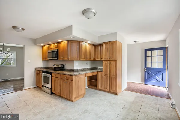 a kitchen with stainless steel appliances granite countertop a stove top oven a refrigerator and a sink