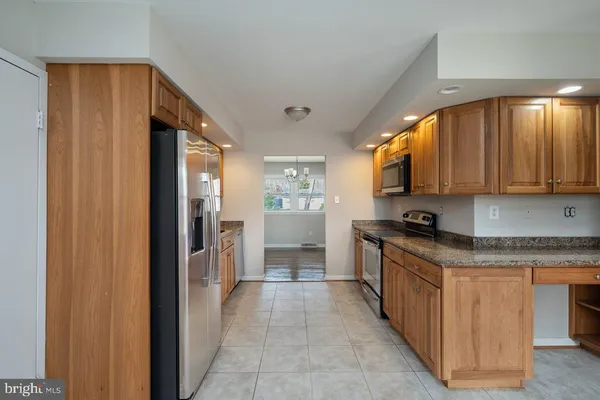a kitchen with stainless steel appliances granite countertop a refrigerator and a stove top oven