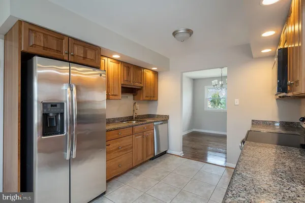 a kitchen with stainless steel appliances granite countertop a refrigerator and a sink