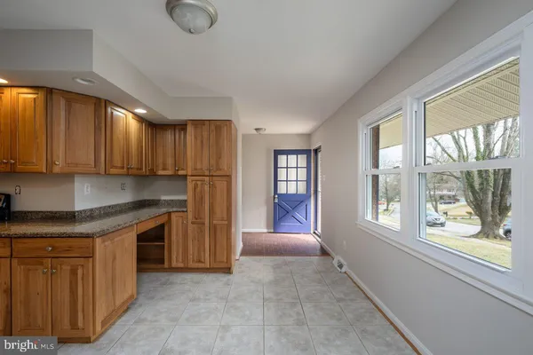 a kitchen with stainless steel appliances granite countertop a refrigerator a sink dishwasher and wooden cabinets with wooden floor