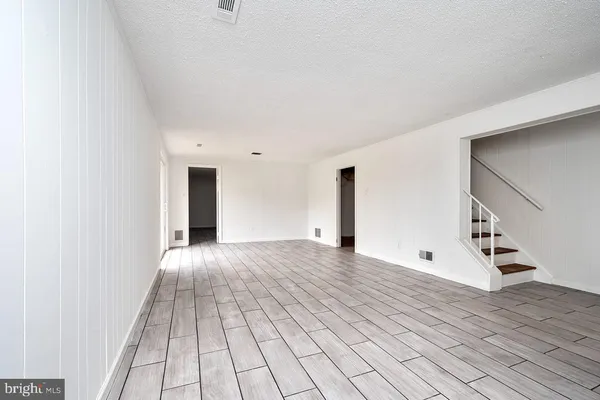 a view of an empty room with wooden floor