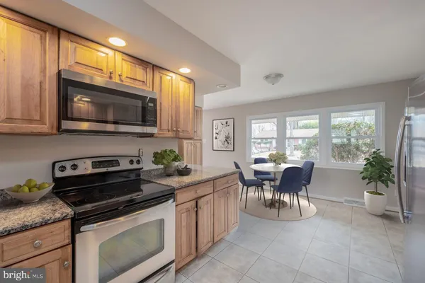 a kitchen with a stove cabinets and dining table